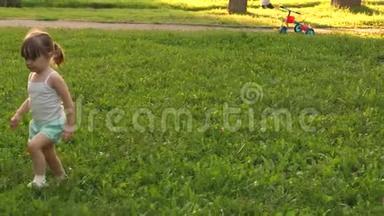 幼稚幸福的概念.. 夏天，快乐的孩子在草地上奔跑，在绿草上奔跑。 活泼开朗的小女孩